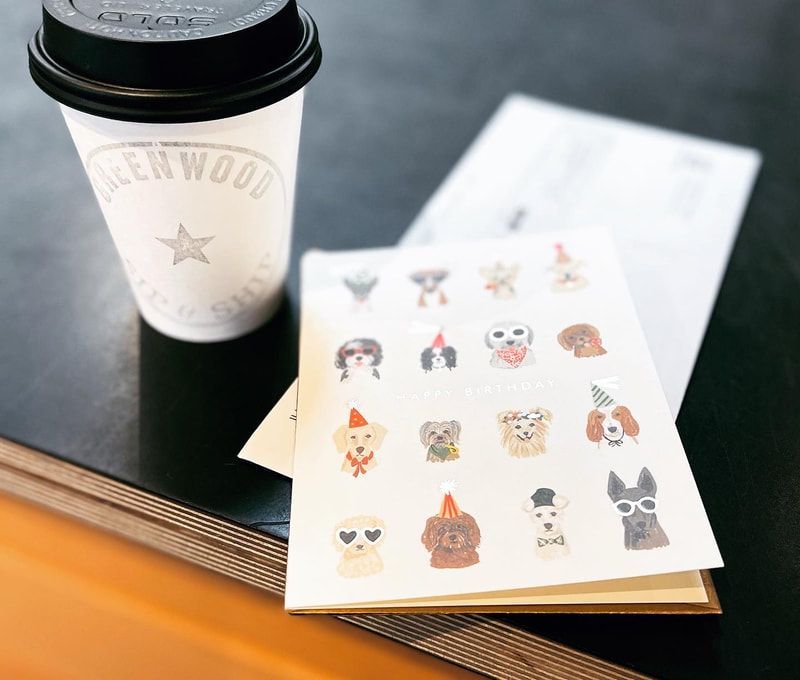 Coffee cup beside an open notebook with cute animal stickers on a table