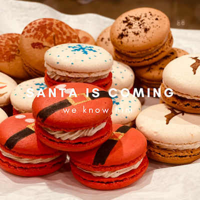 Festive macarons in red, white, and tan with “SANTA IS COMING” text overlay
