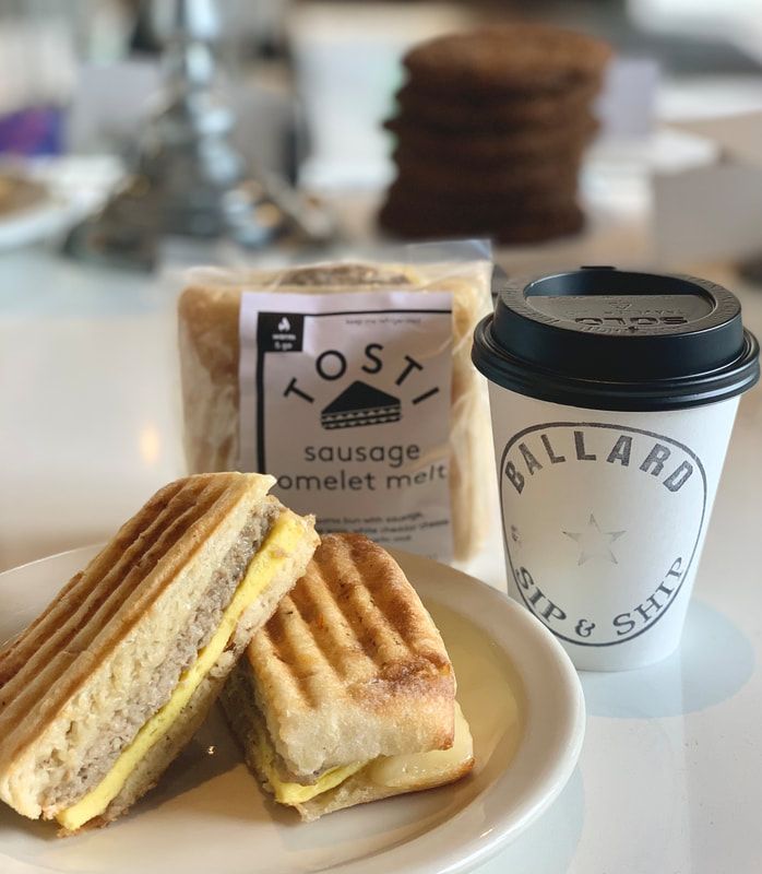 Grilled breakfast sandwich on a plate with a coffee cup and bag of Toast sausage omelet melt