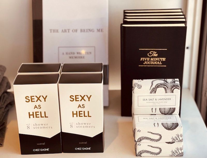 Display of boxed books and small gift items, including two “Sexy as Hell” boxes on a shelf