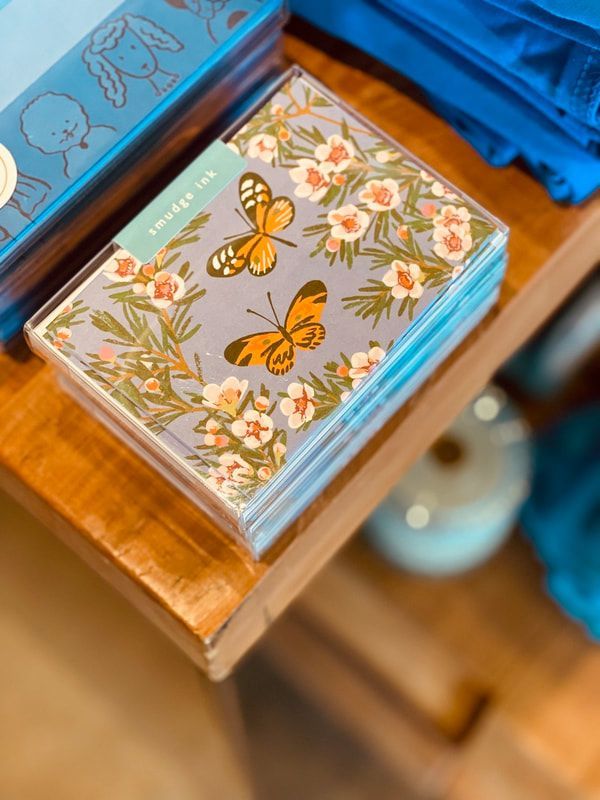 Butterfly and floral decorative box on a wooden shelf with blue accents