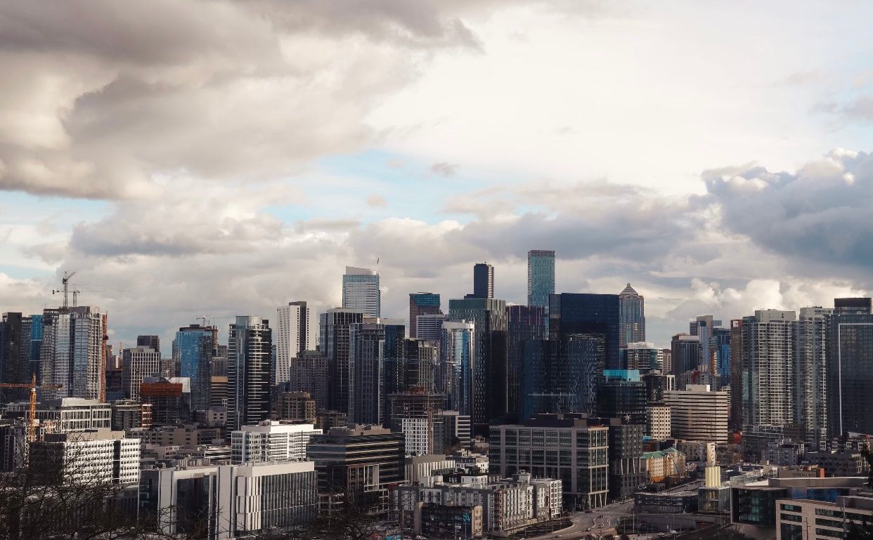 City skyline with high-rise buildings under a cloudy sky.