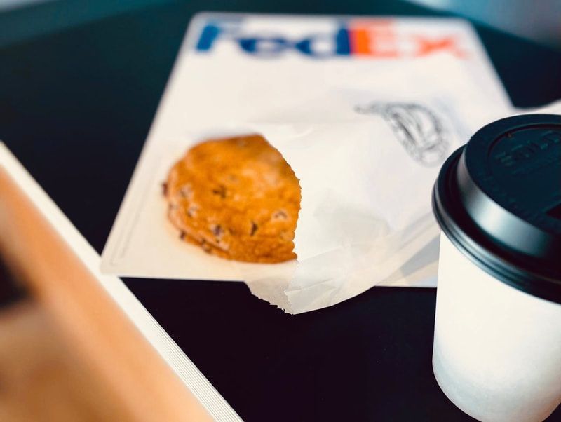 FedEx envelope with a pastry and a coffee cup on a table