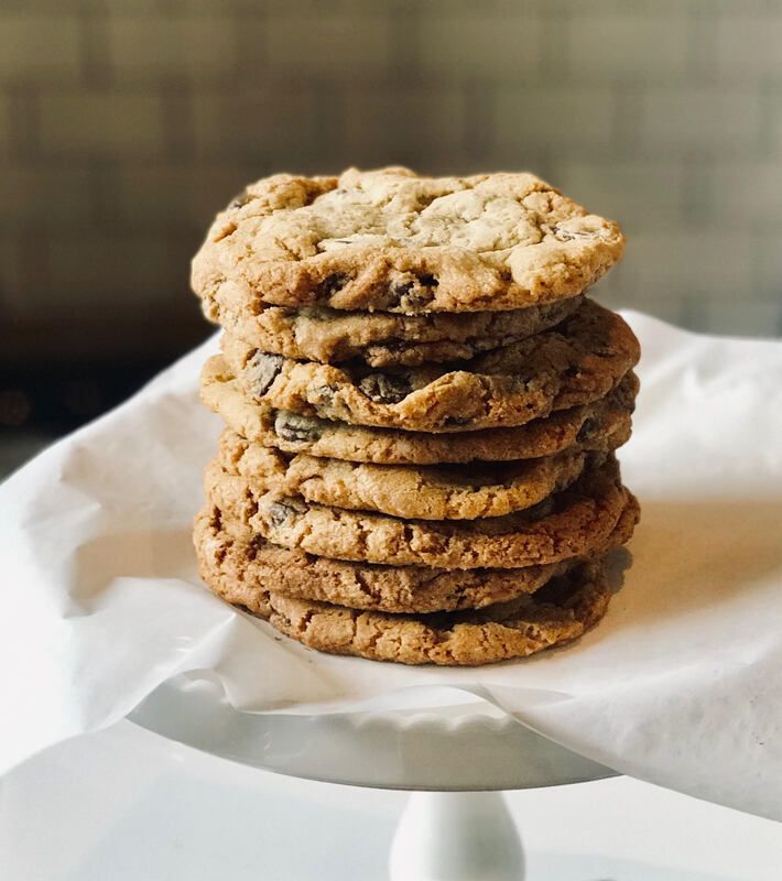 Stack of chocolate chip cookies on white parchment paper on a plate