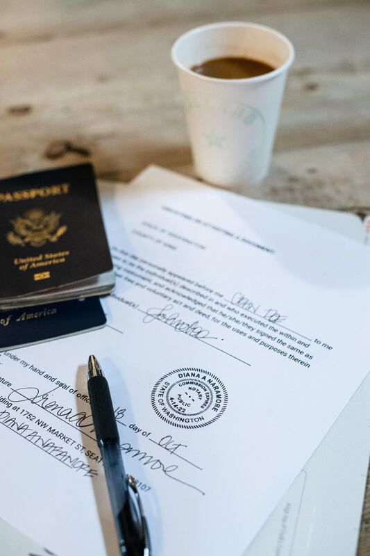 Passport, signed documents, pen, and coffee cup on a desk.