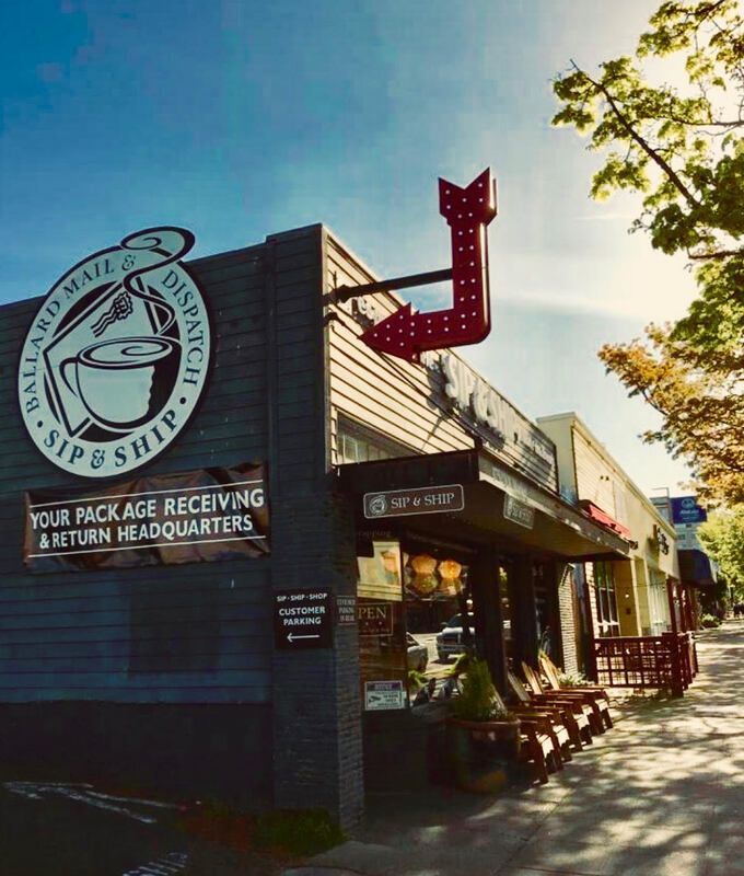 Coffee shop exterior with large circular sign, red neon arrow, and outdoor seating in warm sunlight