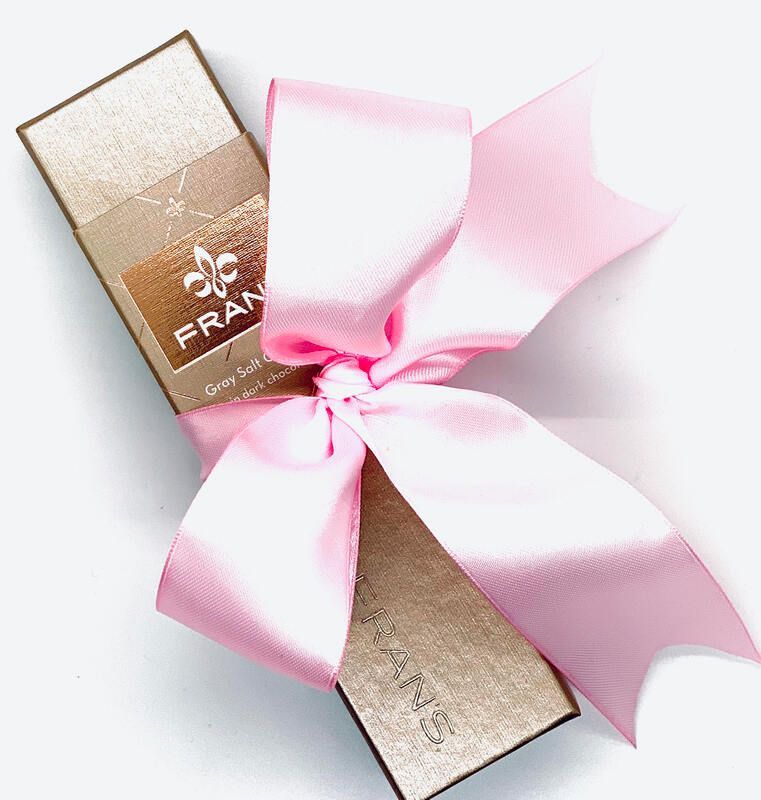 Gold gift box with a pink ribbon bow on a white background