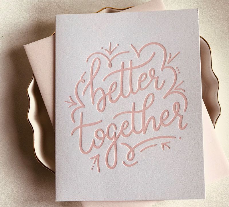 Pink “better together” handwritten card on a folded blush background