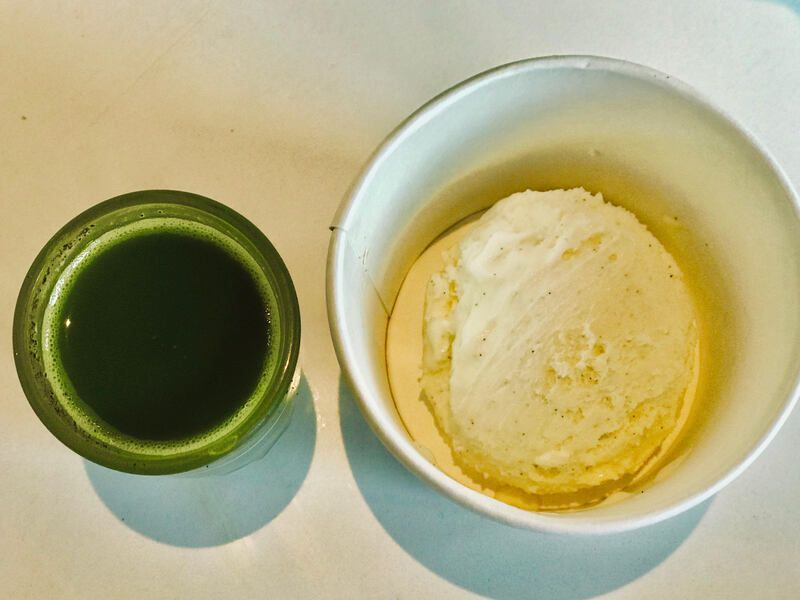 Green matcha cup beside a white bowl of pale yellow ice cream on a table