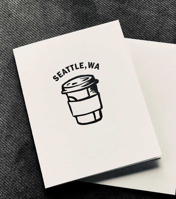 Seattle, WA coffee cup logo on a white card against a textured gray background