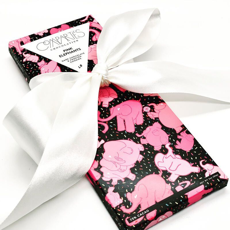 Pink elephant-patterned gift box tied with a large white satin ribbon