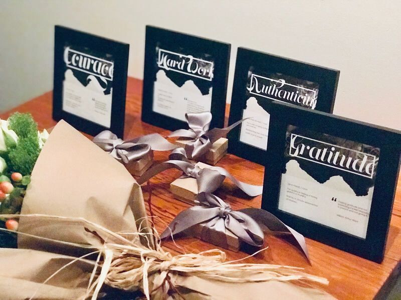 Assorted packaged gifts with name cards tied with silver bows on a table
