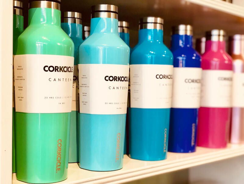 Colorful Corkcicle water bottles lined up on a store shelf