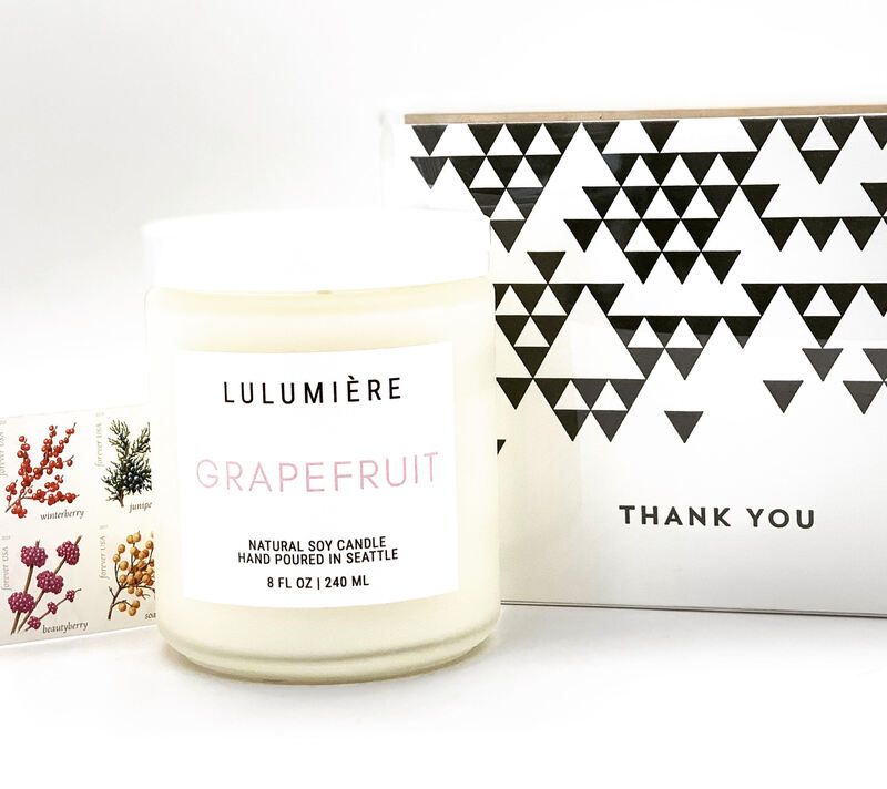 White Lulumière grapefruit candle beside a black-and-white geometric “Thank You” card