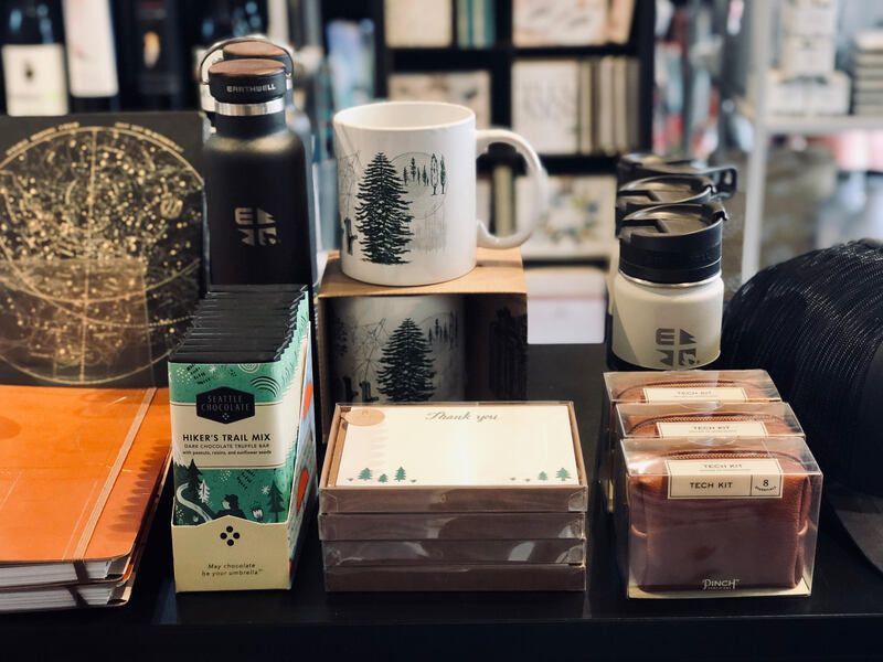 Assorted coffee and tea products on a table, including mugs, tins, boxes, and a bottle.