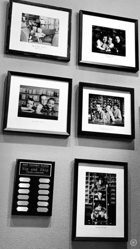 Six framed black-and-white photos and a small plaque arranged on a wall.