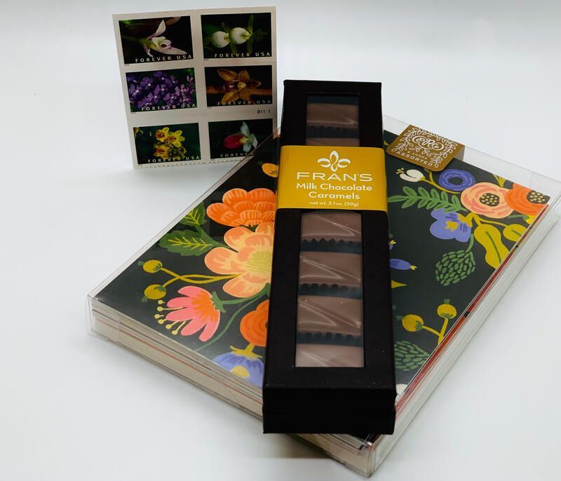 Flower-patterned chocolates in a black box with colorful packaging and sampler display