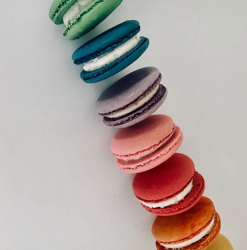 Stack of colorful macarons lined diagonally on a white background