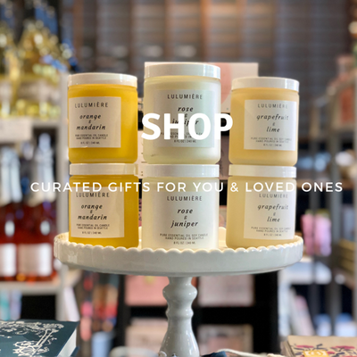 Pastel candles on a white pedestal with “Shop” and “Curated gifts for you & loved ones” text overlay