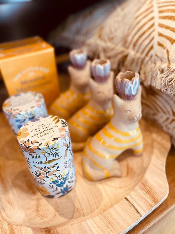 Handmade wooden figurines and floral cups on a wood tray, with yellow-striped and leaf-patterned details