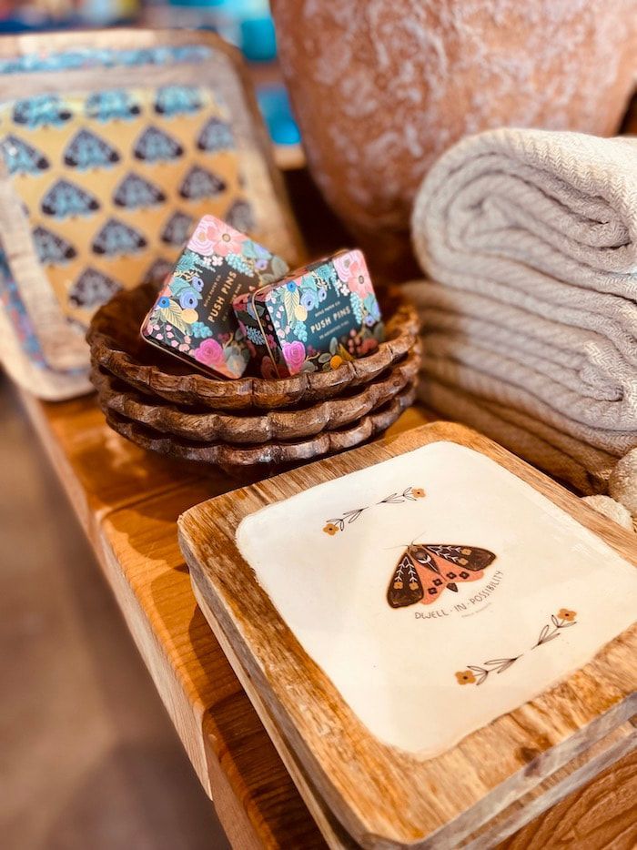 Wooden trays with patterned soaps and folded towels in a spa-like display