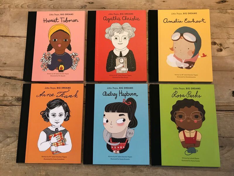 Six illustrated book covers arranged in a 2x3 grid on a wooden surface.