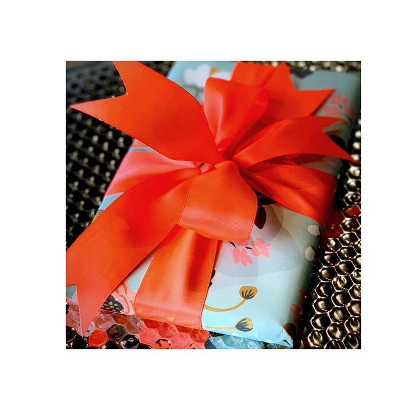 Wrapped gift with a bright red bow on patterned paper and a sparkly background