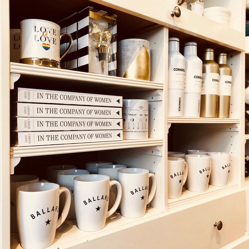 Shelf with white mugs, tumblers, and bottles arranged in a neat home display