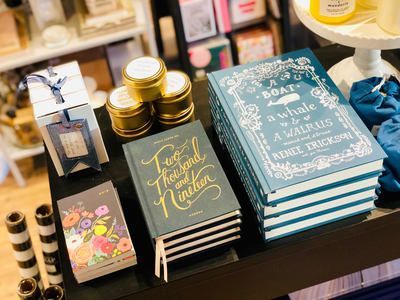 Assorted decorative notebooks and candles displayed on a tabletop with gold accents