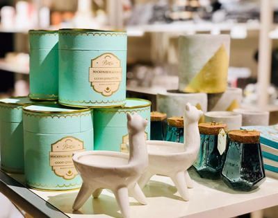 Mint-green product tins and decorative ceramic animals displayed on a store shelf
