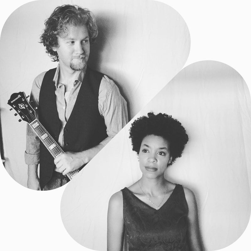Two musicians in black-and-white portrait: a man holding a guitar and a woman posing in front