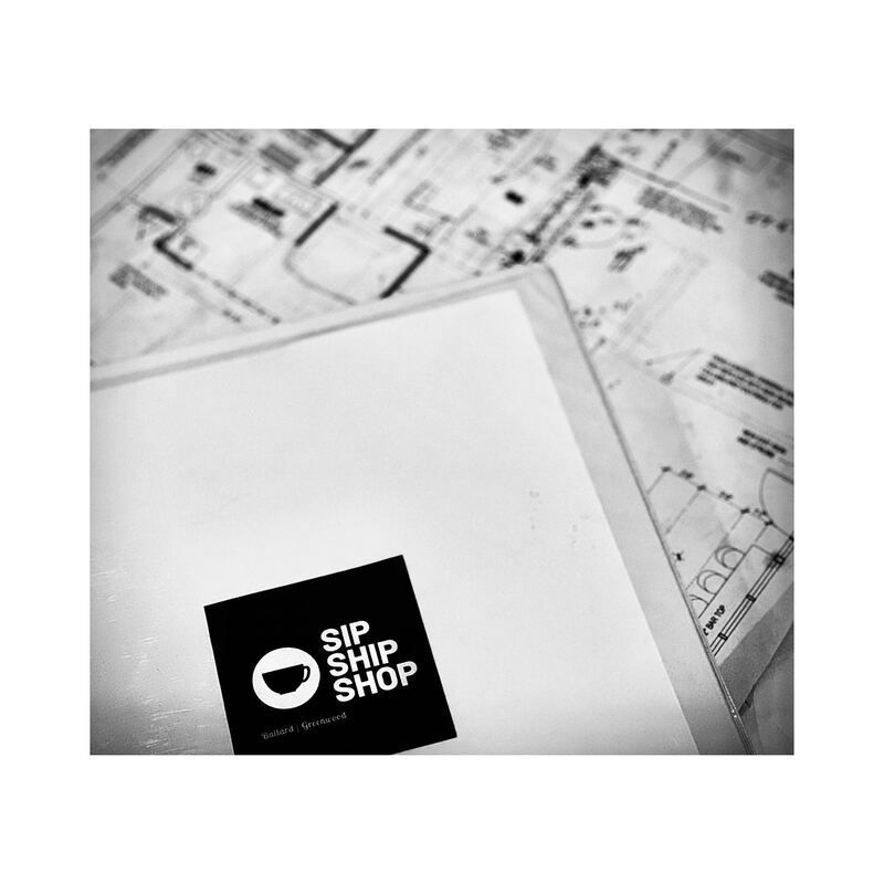 Black-and-white desk scene with papers and a folder labeled “SIP SHIP SHOP”