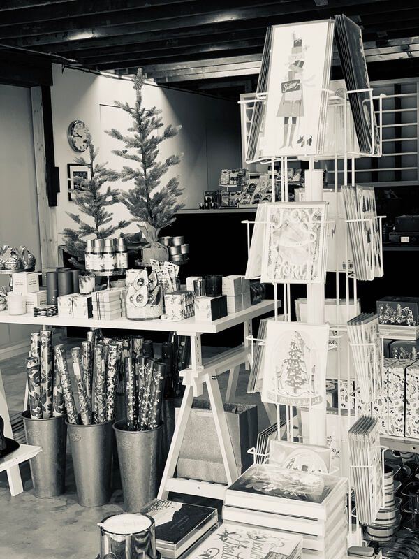 Gift shop display with stacked mugs, candles, and small decor items on tables and shelves