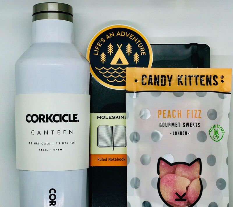 Corkcicle canteen and candy kits in a gift bundle with a circular “Life’s an Adventure” tag