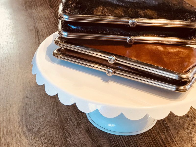 Blue scalloped cake stand holding stacked stainless-steel baking pans on a wooden table