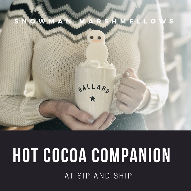 Person holding a Ballard mug with a marshmallow snowman; text reads “Hot Cocoa Companion” and “At Sip and Ship”