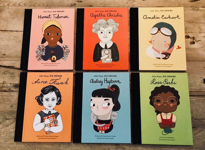 Six illustrated books arranged in a 2x3 grid on a wooden floor, each with a portrait cover.
