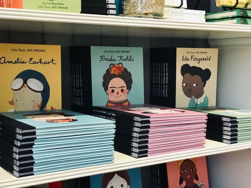 Children’s books displayed on store shelves, with colorful character covers and stacked copies