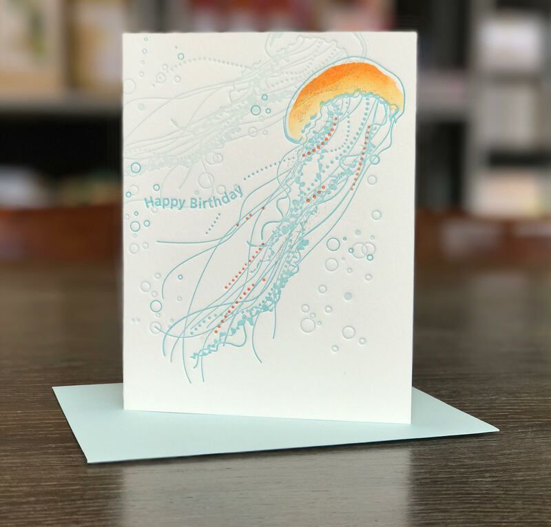 Handmade birthday card with a pastel jellyfish illustration on a table
