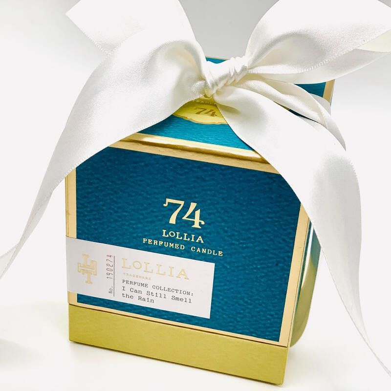 Blue-and-gold gift box with a large white ribbon bow on top