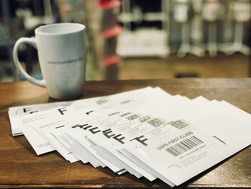 Stack of financial documents beside a white coffee mug on a wooden table.