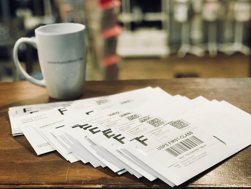 White mug beside a stack of printed financial documents on a wooden table.