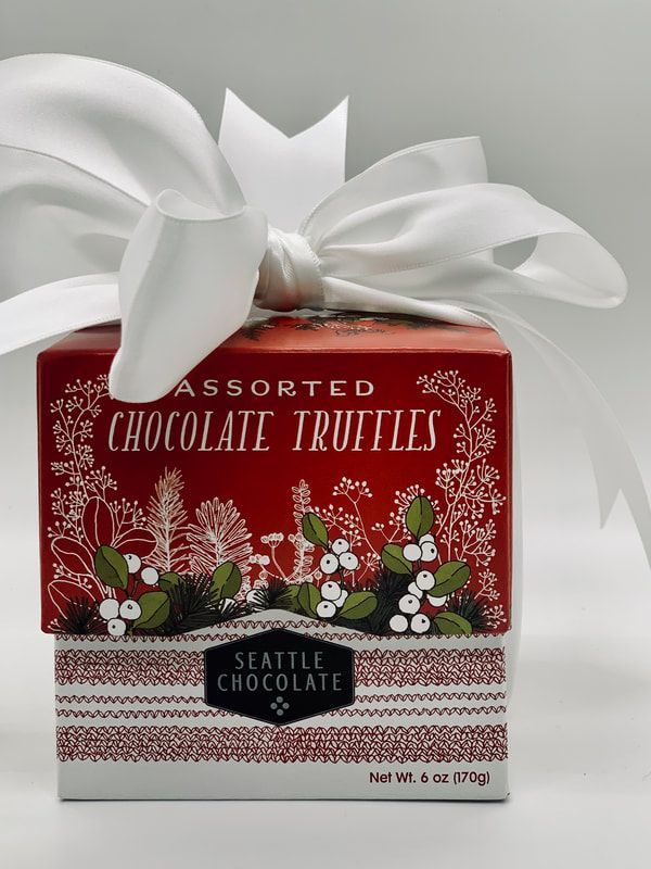Red box of Seattle Chocolate assorted truffles with a large white ribbon bow and floral design
