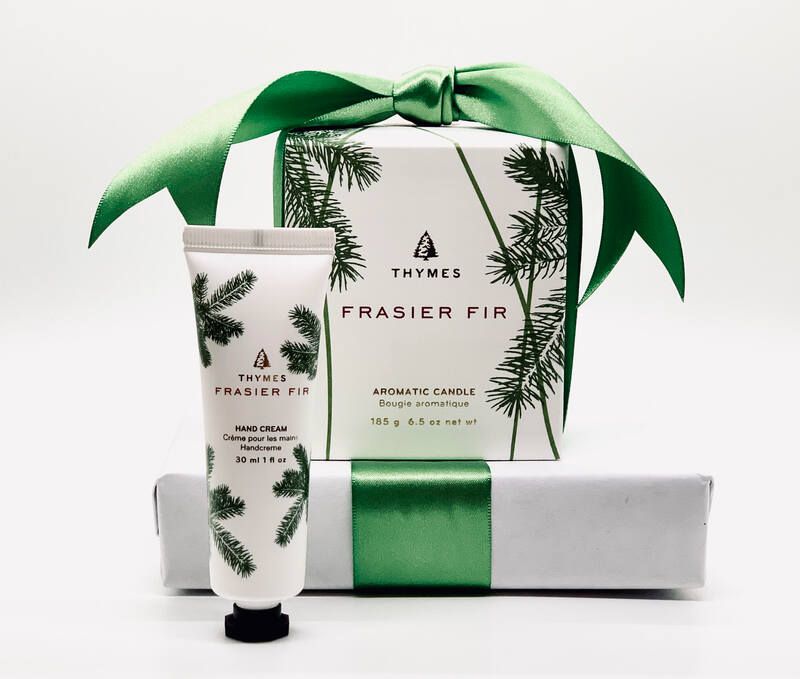 Green-and-white Thymes Frasier Fir gift set with candle, lotion, and wrapped box with pine accents