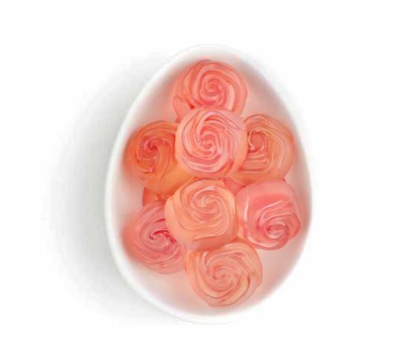 Pink roses arranged inside a white egg-shaped container on a white background