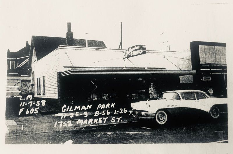 Black-and-white photo of a house and parked cars with handwritten notes on the image