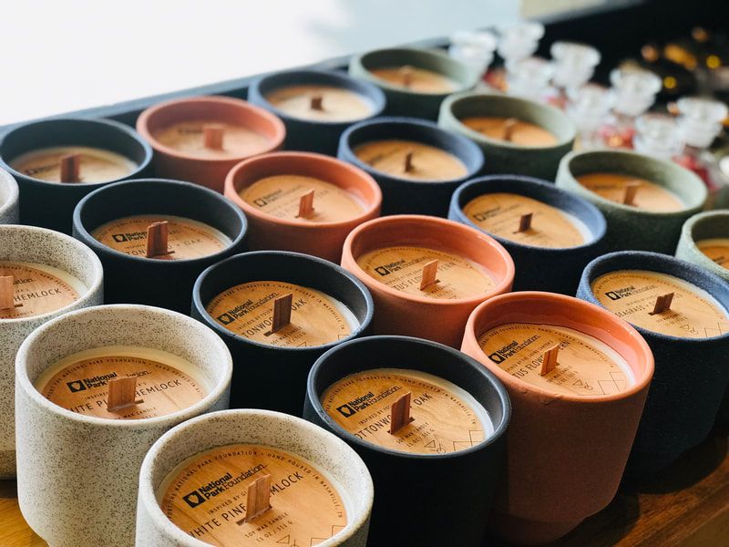 Rows of scented candles in assorted neutral colors, viewed from above.