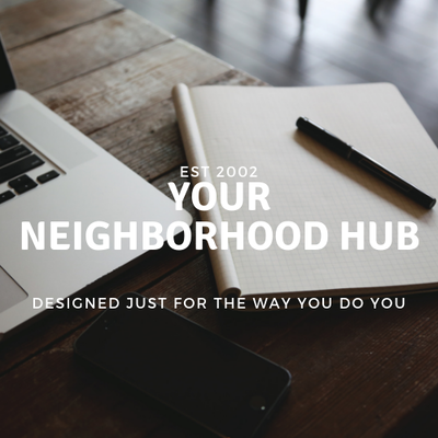 Laptop, notebook, pen, and phone on a wooden desk with text: “YOUR NEIGHBORHOOD HUB.”