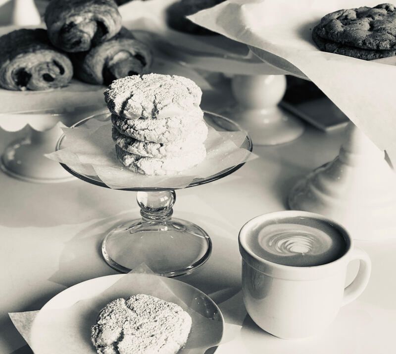 Black-and-white photo of pastries and a cup of coffee on a table