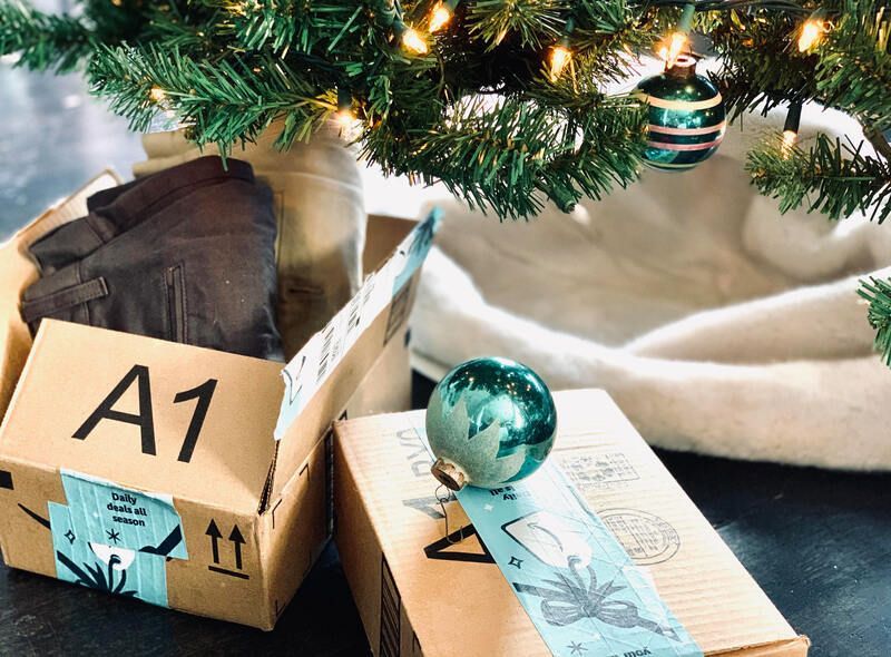Gift box under a Christmas tree with teal ornaments and a tag reading A1